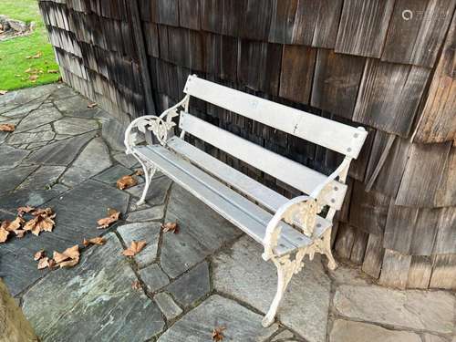 A white-painted slatted wood and cast- iron garden seat,120c...