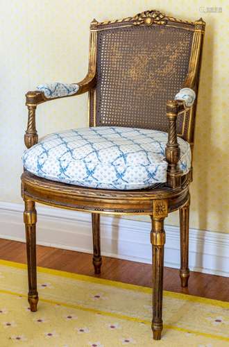 A pair of Louis XVI style gilt-wood and caned back armchairs...