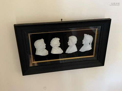 A framed set of four carved white stone busts of famous gent...