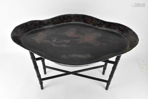 A 19th century Chinese black lacquered tray on stand, the sh...