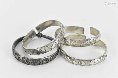 A set of three Chinese white metal torque bangles, with stam...