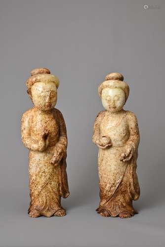 A PAIR OF CHINESE JADE FIGURES. The figures standing dressed...