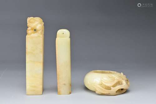 A CHINESE CARVED JADE BRUSHWASHER AND TWO SEALS. All pale in...