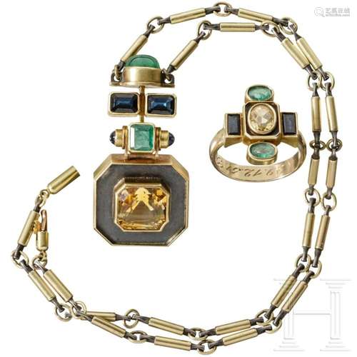 An emerald gold and silver necklace with a gold ring