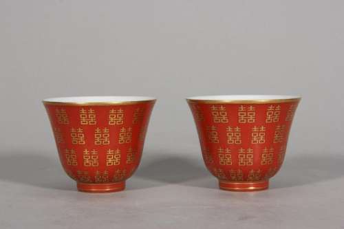 A pair of cups with alum red traced gold Xi character patter...