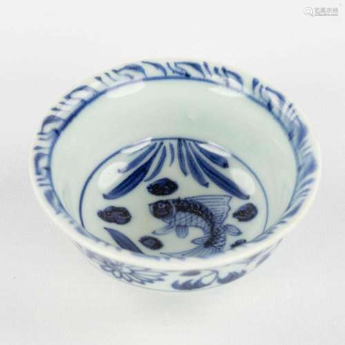 A small Chinese tea bowl with blue-white fish decor. Ming dy...