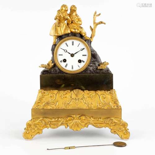 A mantle clock, gilt and patinated bronze decorated with two...