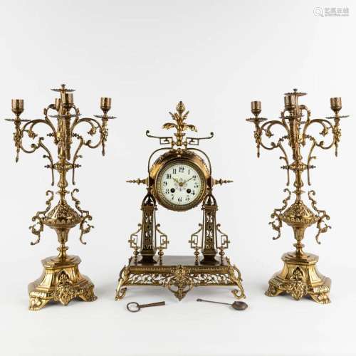 A three-piece mantle garniture clock and candelabra, bronze,...