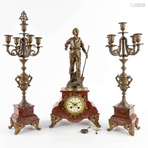 A three-piece mantle garniture clock and candelabra, spelter...