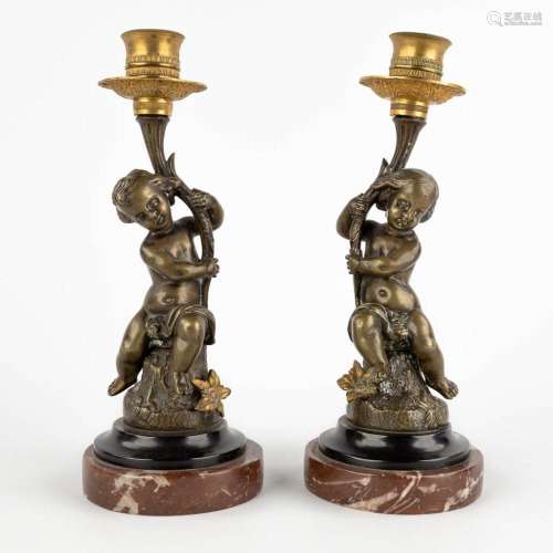 A pair of candlesticks with putti, patinated and gilt bronze...