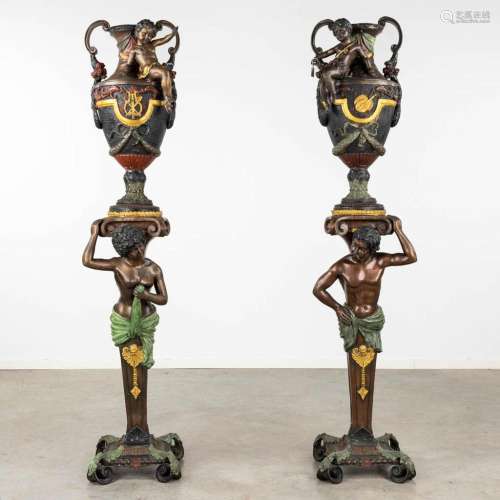 A pair of large urns standing on pedstals, decorated with fi...