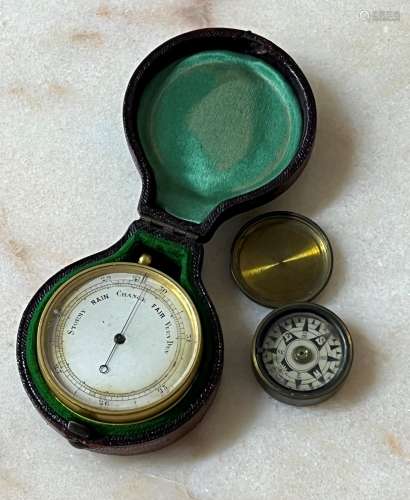 Gilded pocket barometer with a silvered dial and compass set...