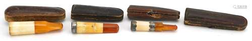 Three early 20th century cigarette holders with amber colour...