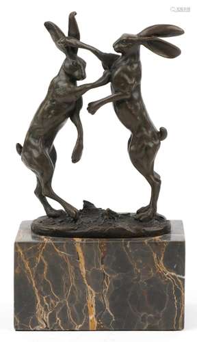 Pair of patinated bronze boxing hares signed Nick, raised on...