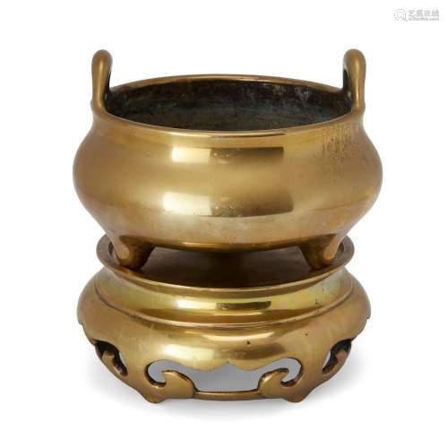A large Chinese polished bronze tripod incense burner and st...