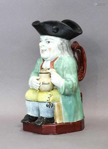 A Pearlware Toby Jug, early 19th century, modelled holding a...