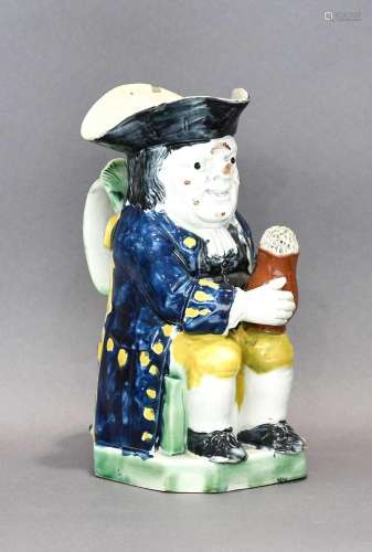A Prattware Toby Jug, circa 1800, of typical form holding a ...