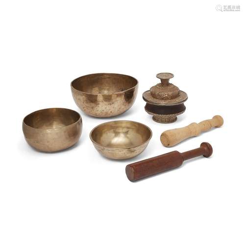 A Tibetan lidded wood bowl and three singing bowls<br />
<br...