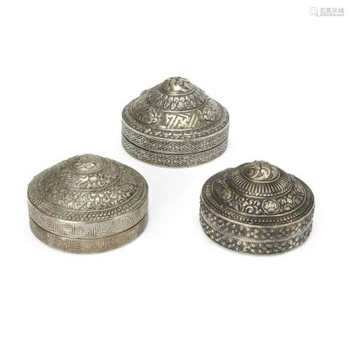 Three Tibetan white metal repoussé circular boxes and hinged...