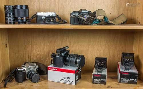 A group of Canon EOS DSLR cameras with lenses and flash