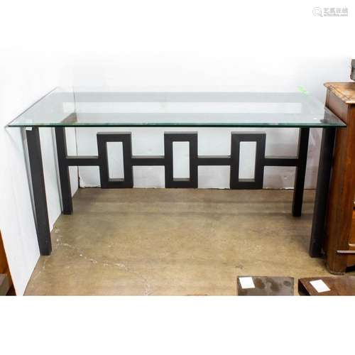 Modern glass top table with ebonized metal base with a friez...