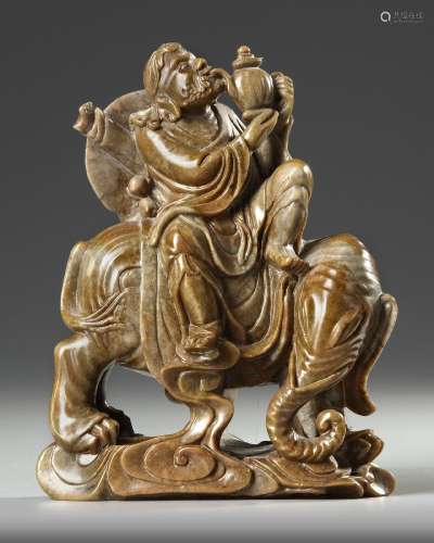 A CHINESE SOAPSTONE CARVED LUOHAN RIDING AN ELEPHANT, 19TH C...