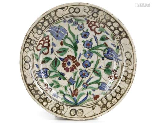 AN IZNIK 'STORM IN A TEACUP' DESIGN POTTERY DISH,  TURKEY, 1...