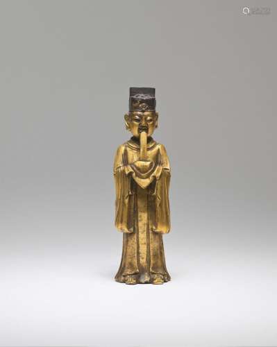 A GILT-BRONZE FIGURE OF A STANDING OFFICIAL Late Ming Dynast...