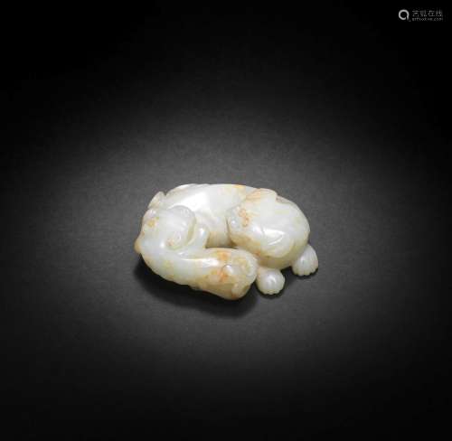 A PALE GREEN AND RUSSET JADE CARVING OF A BUDDHIST LION AND ...