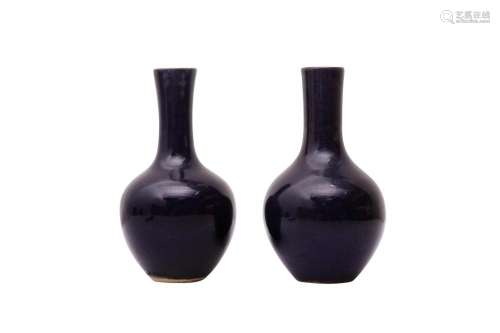 TWO SMALL CHINESE MONOCHROME BLUE-GLAZED VASES 清乾隆 藍釉長...