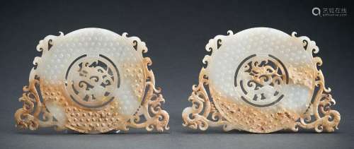 A PAIR OF ARCHAISTIC WHITE AND RUSSET JADE ‘PHOENIXES AND DR...