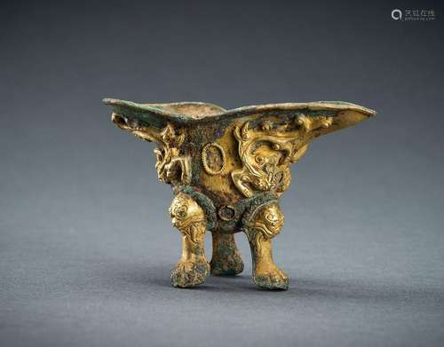 A SMALL ARCHAISTIC FIRE-GILT COPPER REPOUSSÉ TRIPOD WINE VES...