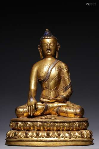 A gilt-bronze and silver-stitched seated figure of Sakyamuni...