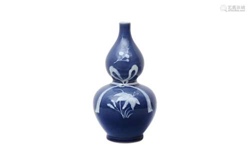 A CHINESE BLUE-GLAZED SLIP-DECORATED DOUBLE-GOURD VASE 二十世...