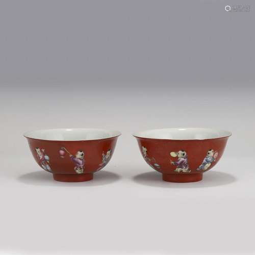 PAIR OF CHINESE FAMILLE ROSE BOYS ON RUBY RED BOWLS