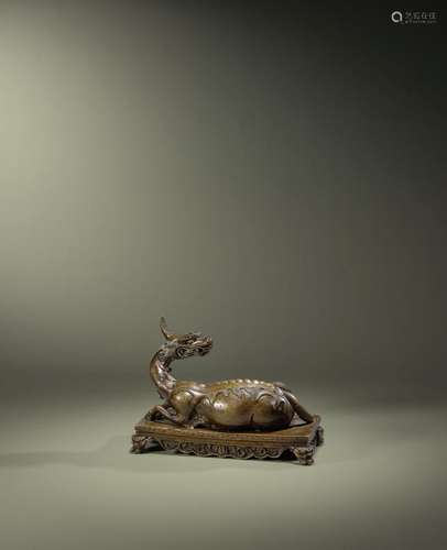 AN UNUSUAL BRONZE FIGURE OF A RECUMBENT DRAGON Qianlong six-...