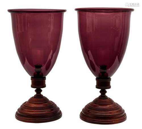 A PAIR OF TURNED MAHOGANY AND AMETHYST GLASS STORM CANDLESTI...