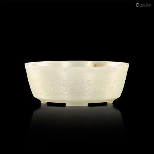 <br />
An imperial pale celadon and russet jade 'taotie' bow...