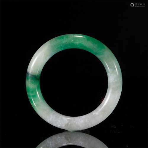 A CHINESE CARVED JADEITE BANGLE