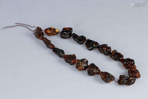 CHINE. Collier en ambre, chacune des 16 perles sculptée