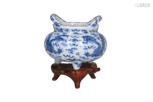 A blue and white porcelain tripod censer on wooden