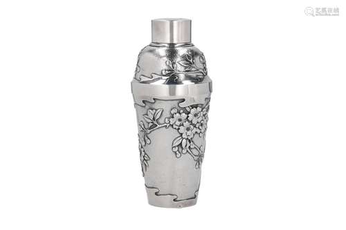 A silver cocktail shaker, decorated in relief with