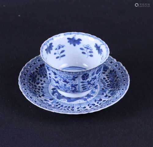 A porcelain cup and saucer with a decoration of, among other...