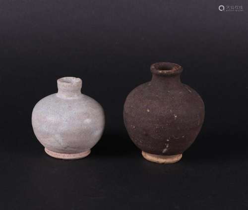 A set of stoneware storage jars. One grey, the other dark gr...