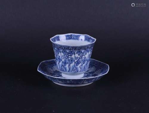 A porcelain 8-sided cup and saucer with floral decor in bord...