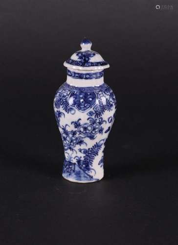 A contoured porcelain lidded vase with a floral landscape de...