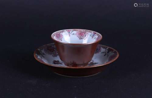 A porcelain Famile Rose cup and saucer with a cupacin exteri...