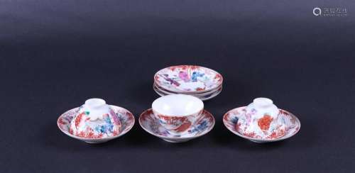 A set of saucers and three cups decorated with various figur...