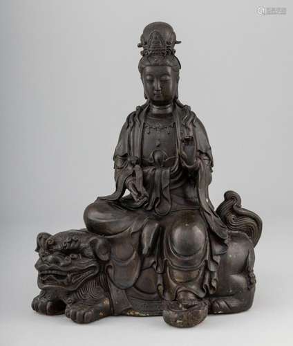 A Chinese bronze figure of Guanyin seated upon a Foo dog. 12...