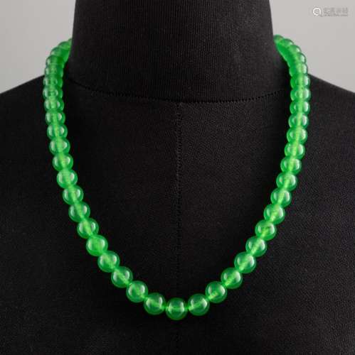 A spinach green jadeite beaded necklace. 11 in. (27.9 cm.) l...